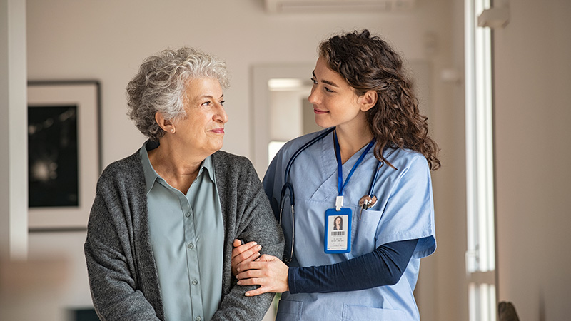 Nurse walking alongside a senior resident and offering a reassuring presence