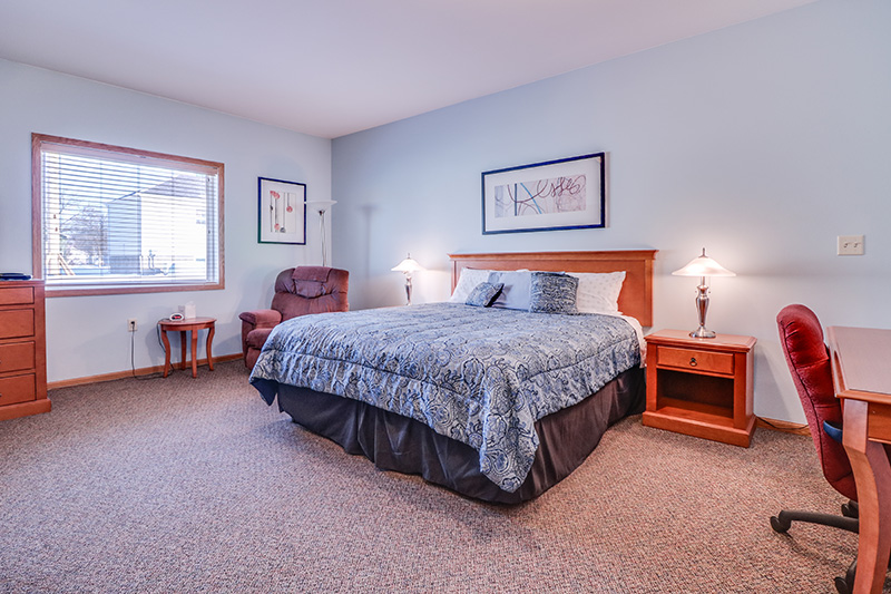 Comfortable single-bed private suite with natural light and sitting area