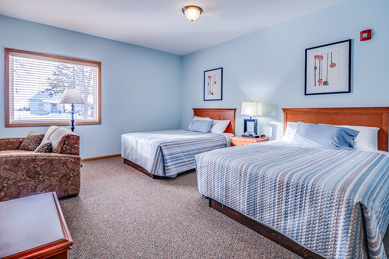 Spacious private suite with dual beds and seating area at Cornerstone Residence of Oklee