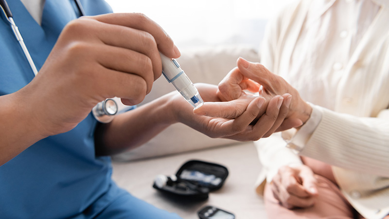 Caregiver checking blood for diabetes care.