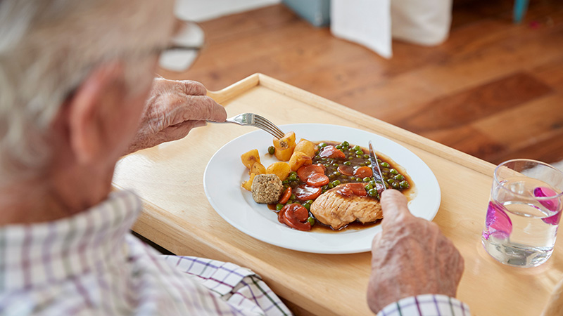Senior resident enjoying a home-cooked meal at Cornerstone Residence of Oklee