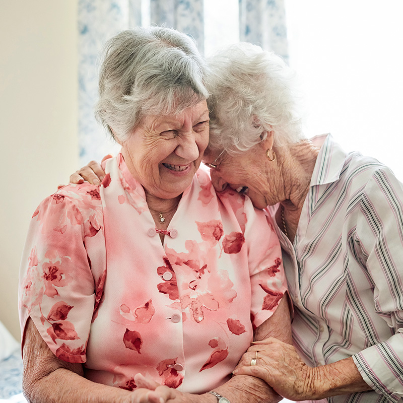 Two senior residents laughing together at Cornerstone Residence of Oklee