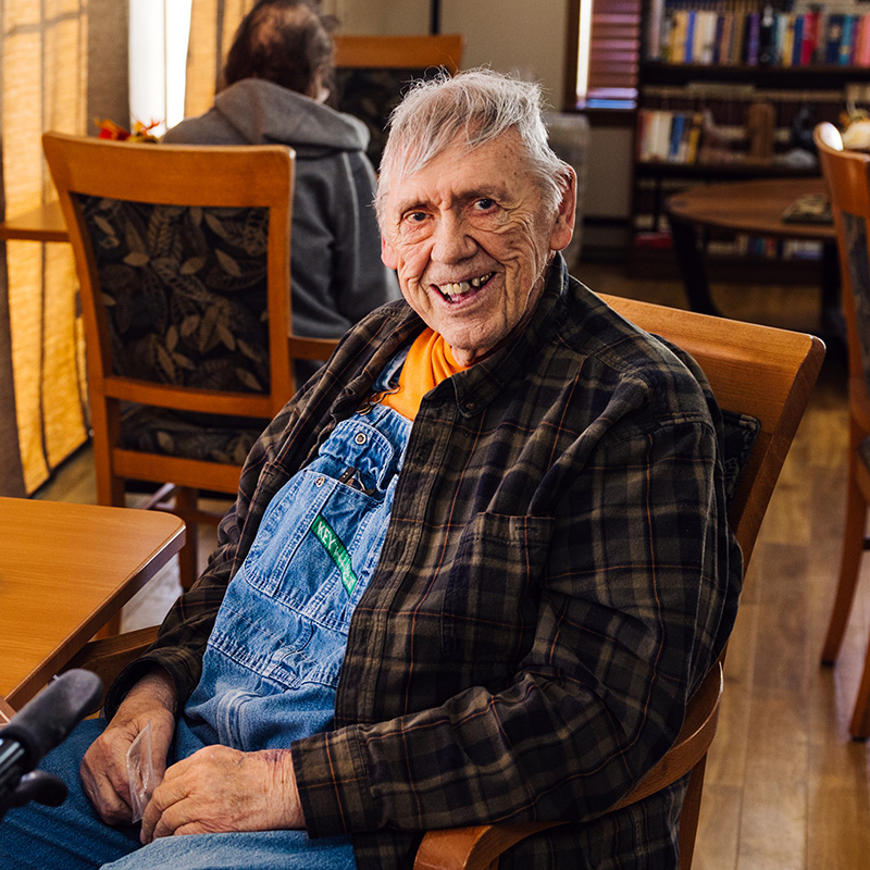 Happy resident relaxing in the common area at Cornerstone Residence of Oklee