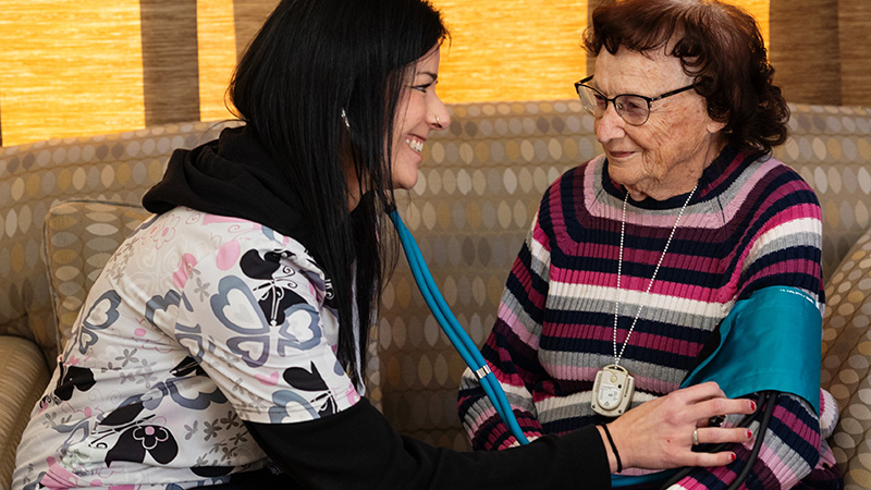 Caregiver checking a resident's blood pressure at Cornerstone Residence of Oklee