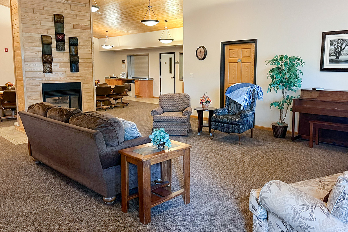 Cozy community living room with fireplace and seating at Cornerstone Residence of Oklee