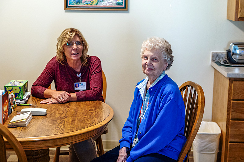 Staff member meeting with a resident in her suite at Cornerstone Residence of Oklee