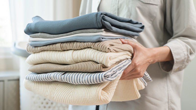 Staff member carrying freshly folded laundry for an assisted living resident