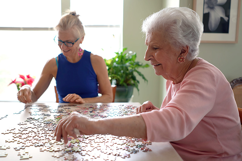 Senior residents working together on a jigsaw puzzle during a social activity